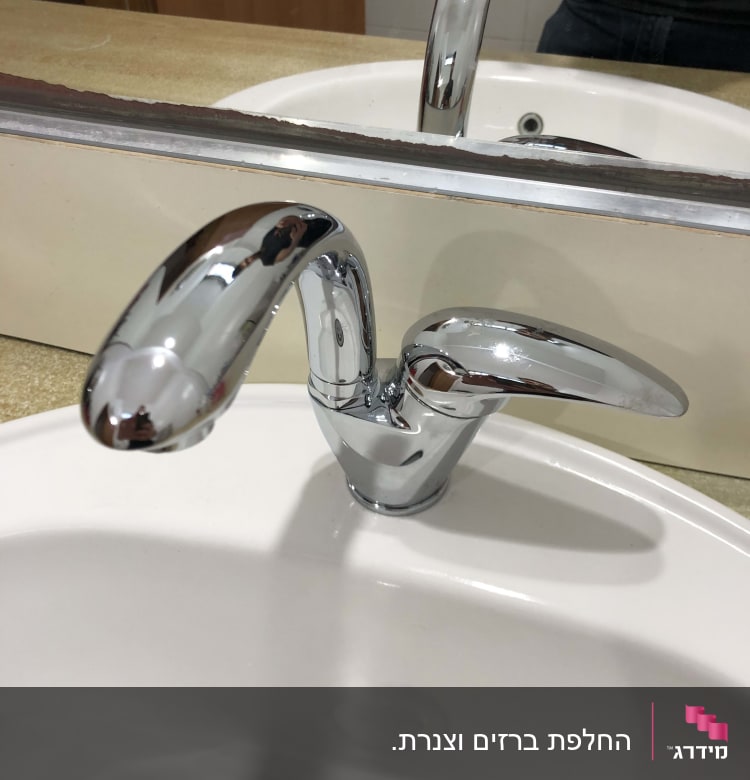 ברז כרום מבריק מותקן בכיור לבן